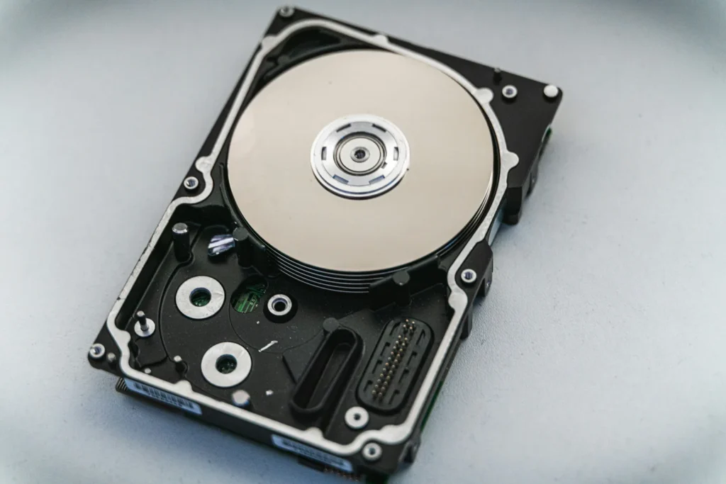 An opened hard disk drive on a pale background